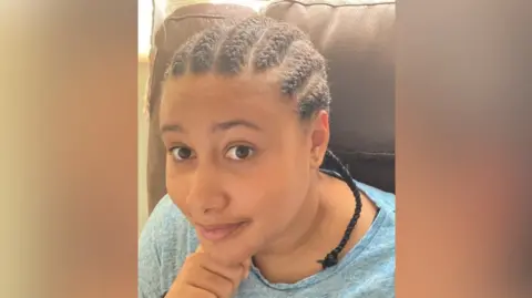 Thames Valley Police Teenage girl looks to camera with a smile on her face. She has dark hair in cornrows and is holding her chin on her hand.