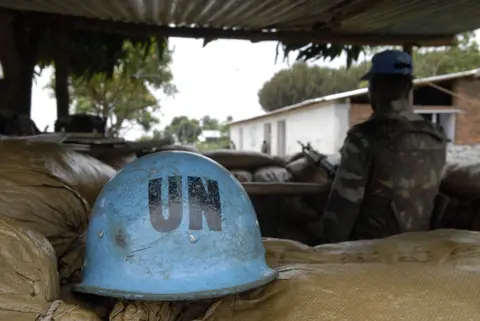 Eddie Gerald / Getty Images A UN blue helmet rests on sandbags needs to a peacekeeper on duty.