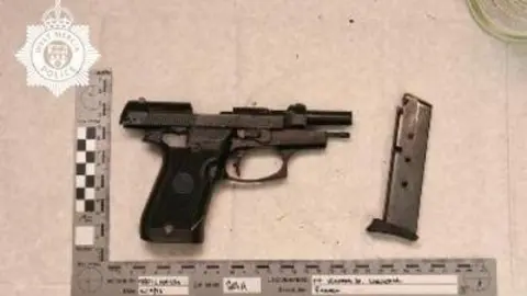 West Mercia Police A gun is photographed next to a ruler with measurements. The photograph, taken by police, has the force logo on it.