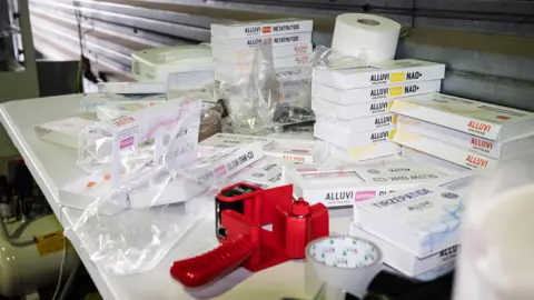 Lincolnshire Police A white table full of rectangular white packaging which say various words on them including 'Alluvi', 'Tirzepatide' with cellotape and clear packaging also seen.