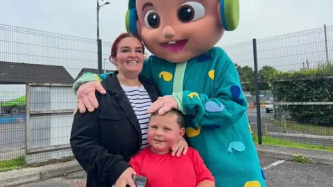 A women and her son standing staring into the camera.