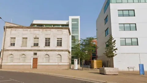 Streetview image of Colton Square, a paved area formed by a mix of modern and traditional buildings