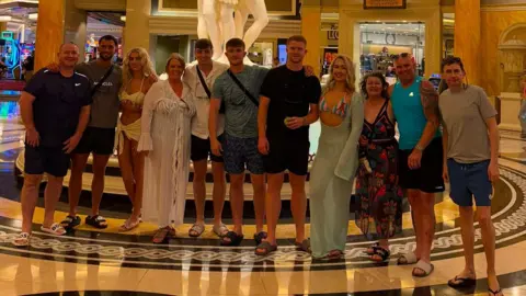 Supplied A family from Merseyside poses in a Vegas casino, they appear to be in Caesars Palace as they all smile for the camera wearing t-shirts, shorts and beachwear.