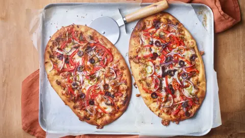 A top-down view of two naan pizzas fresh from the oven.