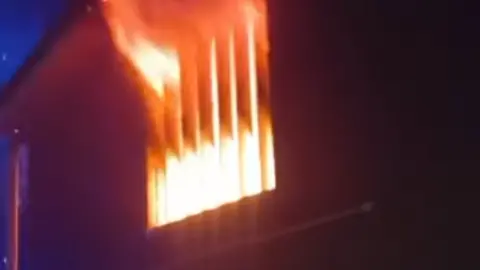 Jersey Fire and Rescue Flames coming out the side of a building