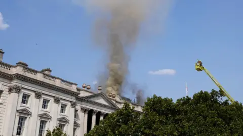 Reuters: Smoke rises as firefighters work at the scene of a fire at Somerset House in London