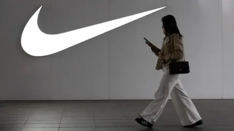 A woman walks past a Nike store in Beijing, China, 8 April 2025.