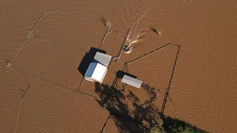 Reuters a home stranded amid brown floodwater seen from above