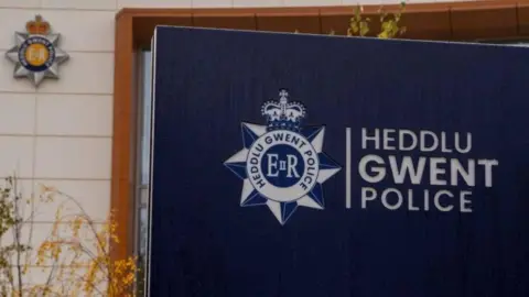 A blue sign bearing the words 'Heddlu Gwent Police' in white capitals.
