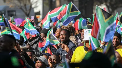 EPA supporters outside the Union Buildings wave South African flags