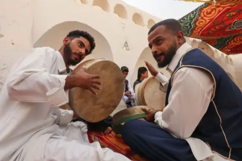 MAHMUD TURKIA/AFP Musicians dressed in traditional attire play during the Ghadames Festival celebrating the cultural and artistic heritage of the Libyan city.