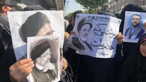 EAP Iranians hold portraits of late president Ebrahim Raisi as they mourn during a funeral processions ceremony in Tehran, Iran, 22 May 2024