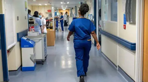 PA Media Nurse walking in a ward