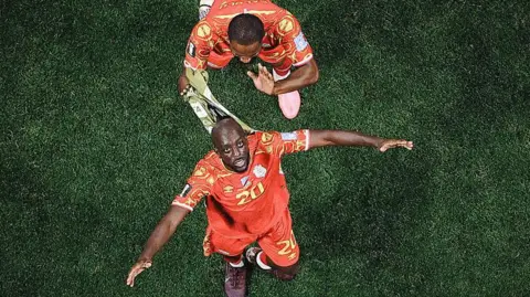 Getty Images Overhead shot of Yoane Wissa and Gedeon Kalulu of Congo DR celebrate after the 3-1 win during the FIFA World Cup 2026 Group K match between Congo DR and Uzbekistan.