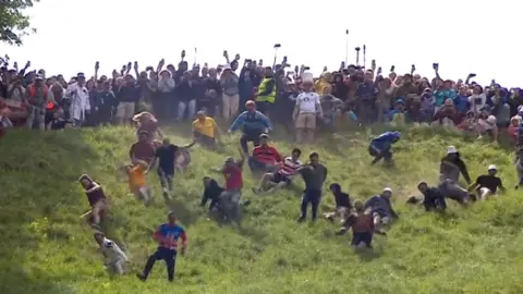 People doing cheese rolling