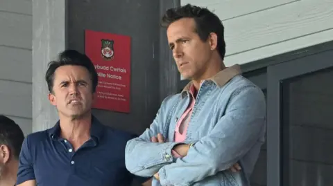 PA Media Wrexham co-owners Rob McElhenney and Ryan Reynolds in the stands during a Championship match at the SToK Cae Ras, Wrexham. 