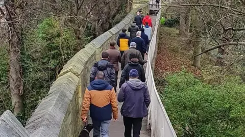 Menfulness A mixed group of men walk together down York City Walls.