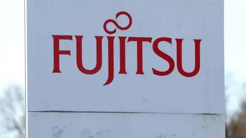 Reuters Fujitsu sign with red lettering on a white board