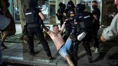 Os policiais da Reuters detêm um manifestante em Belgrado