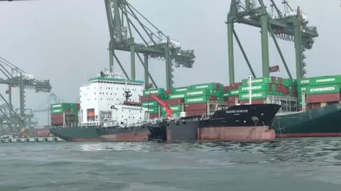 SINGAPORE GOVERNMENT Oily, dark water surrounds the struck vessel 