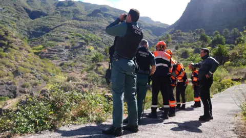 PA Media Spanish Guardia Civil officers and mountain rescue units peer into a ravine during the search for Jay Slater