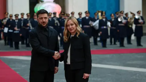 Reuters Ukraine's President Volodymyr Zelenskiy shakes hands with Italy's Prime Minister Giorgia Meloni at Chigi Palace in Rome.