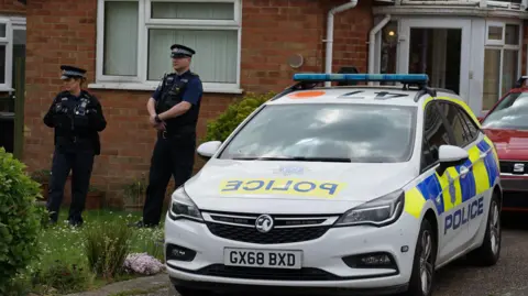 Dan Jessup An image of a Sussex Police vehicle outside a property on College Road, Bexhill. Two police officers are stood outside the property.