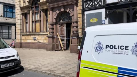 Police vehicles parked outside the former National Westminster Bank in Great Yarmouth, where the doors have been smashed in