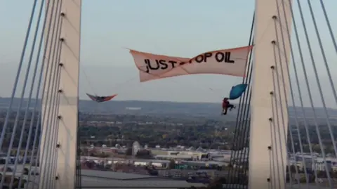 PA Media Shot of two protesters hanging from Dartford Crossing Bridge