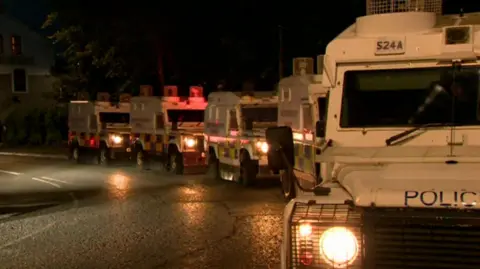 Police vehicles in a line on a street