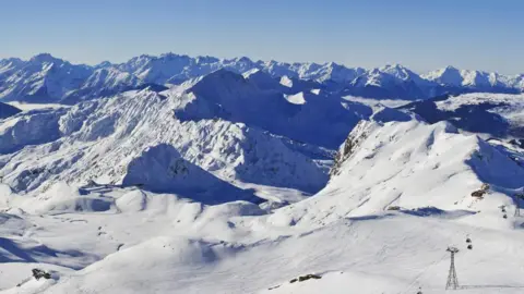 Getty A white snowy mountainous landscape with a blue sky above is captured from the top of La Plagne ski resort in France. 