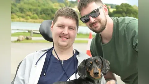 Family handout Rob and Tom with a small dog