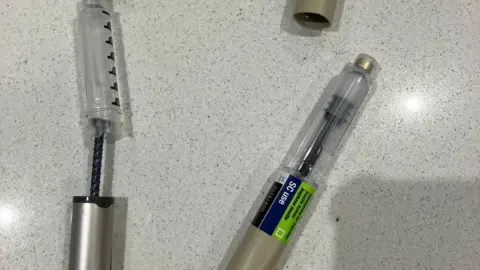 Two different types of insulin pens are shown: one has a silver body and the other has a plastic body.