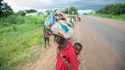 AFP Displaced people from the province of Cabo Delgado walk through the streets of Namapa, Erati district of Nampula, Mozambique on February 27, 2024