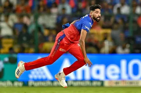 AFP Royal Challengers Bengaluru's Mohammed Siraj delivers a ball during the Indian Premier League (IPL) Twenty20 cricket match between Royal Challengers Bengaluru and Delhi Capitals at the M Chinnaswamy Stadium in Bengaluru on May 12, 2024. (Photo by Idrees MOHAMMED / AFP) 