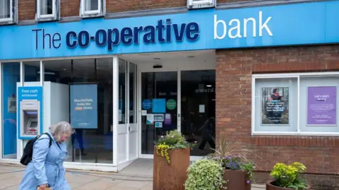 A woman outside Co-operative Bank