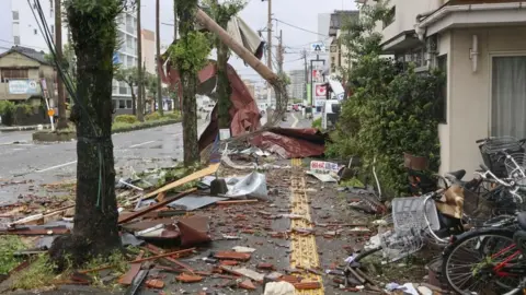 Reuters Puin en voorwerpen die op 29 augustus 2024 door harde wind zijn weggeblazen op een weg in Miyazaki, in het zuidwesten van Japan. 