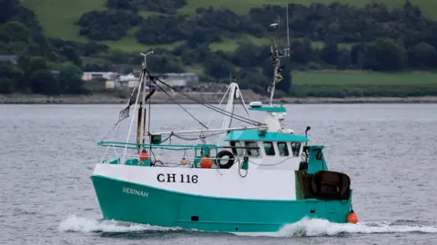 Marine Accident Investigation Branch A small fishing boat, painted turquoise and white, sailing across the waters
