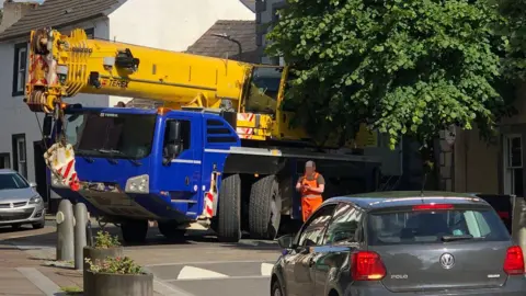 Mark Proctor A yellow crane on a blue lorry stuck at the junction