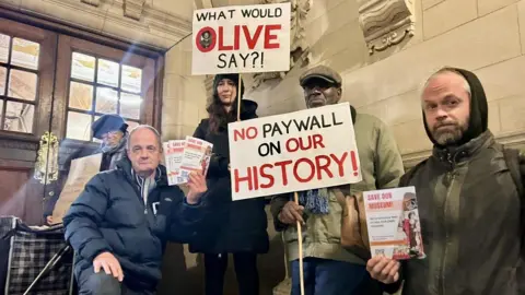 Protestors from 'Save Our Museum' outside Oxford Town Hall in November. They are holding placards opposing the fees.