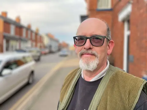 A man in sunglasses stood in the street