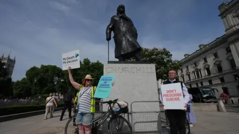 PA Campaigners in support and opposition to the assisted dying bill gather under the statue of Winston Churchill, in London