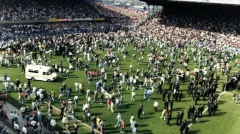 Hillsborough Inquests Ambulance and people on the pitch during the Hillsborough stadium disaster.