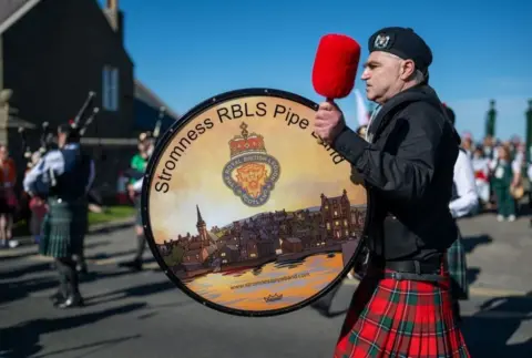 Muckle Media A man playing the drum wearing a kilt from the Stromness RBL Pipe band