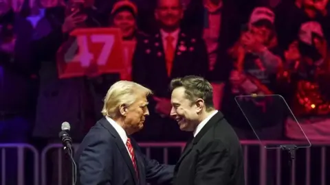 Presiden EPA AS Donald Trump (L) dengan pengusaha Elon Musk (R) di atas panggung selama rapat umum di Capital One Arena di Washington, DC pada tanggal19 Januari 2025