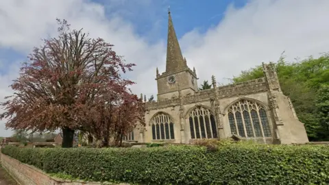 Google Maps A view of St Nicholas church in Bromham, where many members of the Bayntun family are buried. Sunny day, a green fence outside and a large tree with reddish leaves on the left