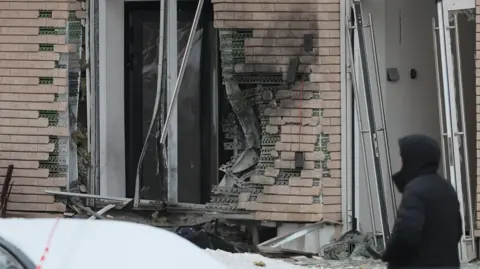 Damage to brickwork and windows is seen on the outside of an apartment block in Moscow