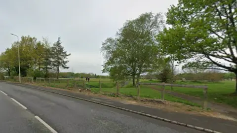 Google Maps A view of Upavon Way in Carterton, next to empty green field. It is overcast.