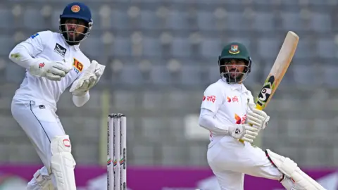 Sri Lanka wicketkeeper Kusal Mendis watches Bangladesh batter Mominul Haque hit out in 2024