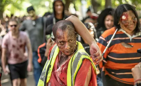 Brenton Geach /Gallo Images / Getty Images Participants wearing fake blood and scabs taken part in the Zombie Walk Festival in Cape Town, South Africa - Saturday 1 November 2025.